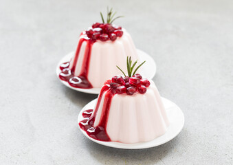 Vegan dessert. Pomegranate Cream pudding, Panna Cotta with pomegranate sauce. On a plate. Light gray background. Close-up