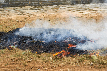 A pile of burning straw outdoors in the countryside - obrazy, fototapety, plakaty