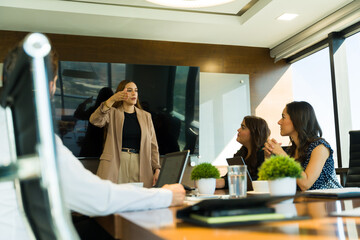 Female boss giving instructions to some of her staff in a business meeting