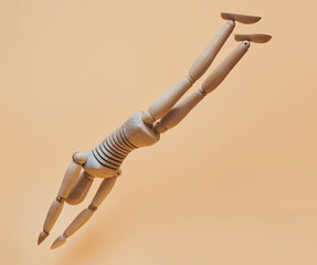 A wooden mannequin simulates a jump into water from a height. Diving, swimming and sport concept.
