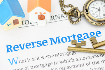 Model houses on a reverse mortgage document. A reverse mortgage is a loan for homeowners,...