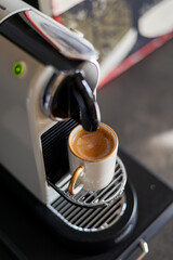 Espresso coffee machine with coffee pods. Close up photo with an espresso in a white ceramic pot.