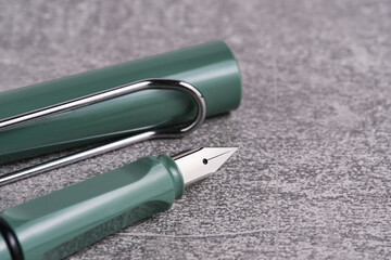 Fountain pen is green on a gray background.