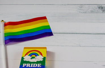 Pride box and a rainbow flag on white table