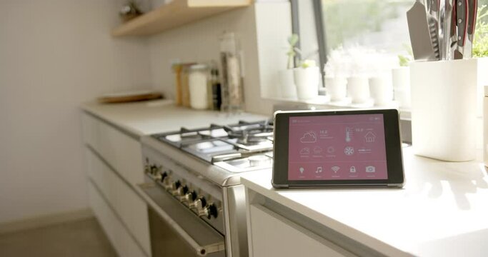 A modern kitchen boasts a smart home interface on the counter, copy space