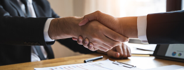 client and banker shaking hands  on the meeting table after business investment budget done