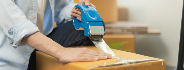 close up person sealing tape on parcel box prepare for delivery service to pick up.