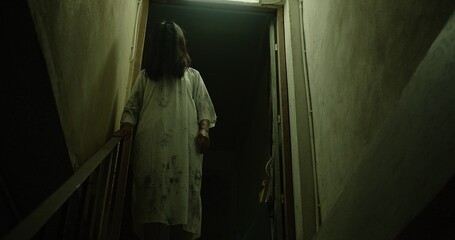 A woman ghost in a white dress is standing on a dark hallway stairway. Scene is spooky scary nightmare mystery, halloween holiday - obrazy, fototapety, plakaty