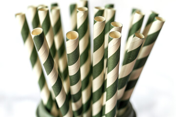 Close-up view of green and white striped paper straws in a holder - obrazy, fototapety, plakaty