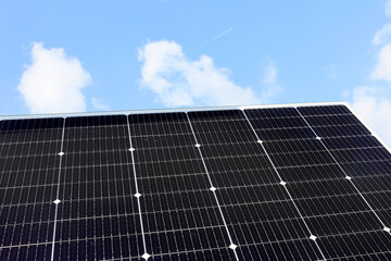 Solar panels against blue sky in a solar energy power plant used to produce electricity from the sunlight. Clean and renewable energy, power in nature.