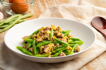 Stir Fried french green beans with egg and Minced Pork with oyster sauce in white plate