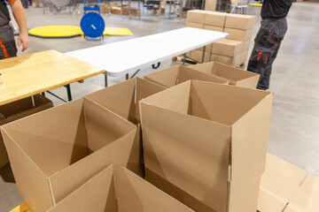 Stack of empty cardboard boxes at a packaging station in a warehouse facility - 759964010