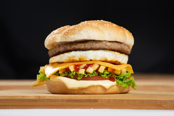 Close-up of beef burger on white background. Hamburger - bun, grilled meat burger, lettuce, tomato and fried egg.