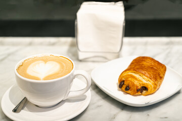 photo of Colombian coffee decors with a cream heart on the top and fresh bread in a bakery