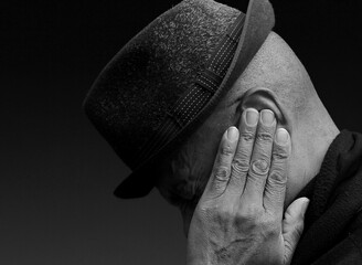 deaf man suffering from deafness and hearing loss on grey background with people stock photo	