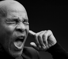 deaf man suffering from deafness and hearing loss on grey background with people stock photo	