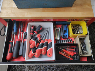 Detail of the open screwdriver drawer of the small tool cart in the apartment