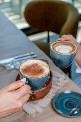 Cup with hot cappuccino with foam on the table. coffee art.