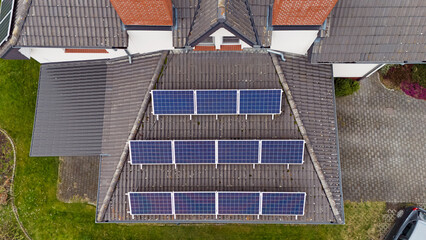Dach nowego, współczesnego budynku wielorodzinnego z panelami słonecznymi, fotowoltaiczne, widok z lotu ptaka. - 760042024