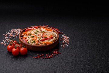 Delicious rice noodles or udon with chicken, carrots, pepper, salt, spices and herbs