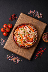 Delicious rice noodles or udon with chicken, carrots, pepper, salt, spices and herbs
