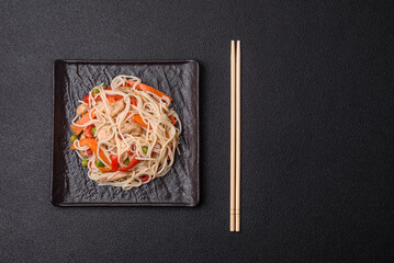 Delicious rice noodles or udon with chicken, carrots, pepper, salt, spices and herbs