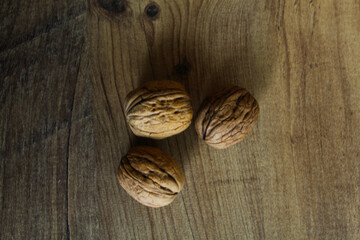 Three unbroken walnuts lying on the ground