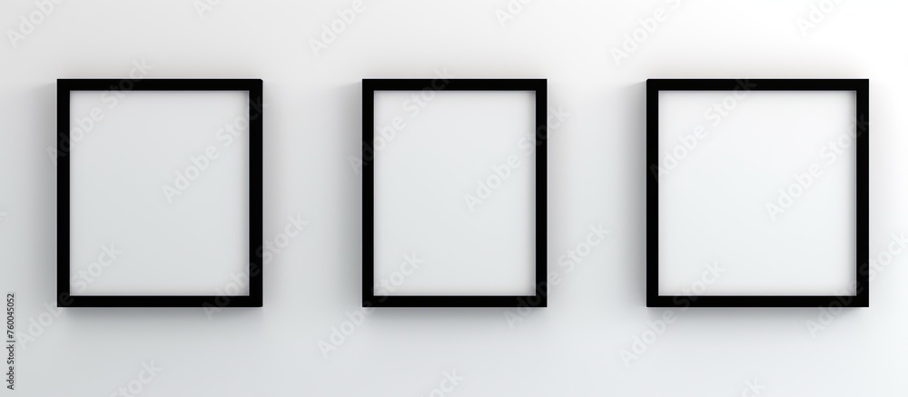 Poster three rectangular black frames are symmetrically hung on a white wall, creating a visually pleasing 