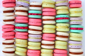 Many colorful French macaroons dessert on a white background. Handmade almond macarons  for breakfast or Birthday, coffee break, gift. Close up