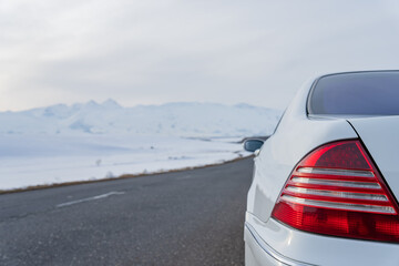 White car on asphalt road in winter, winter travel