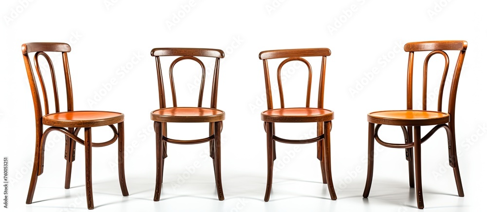 Poster four wooden chairs are arranged in a line on a white surface, creating an artistic display of outdoo