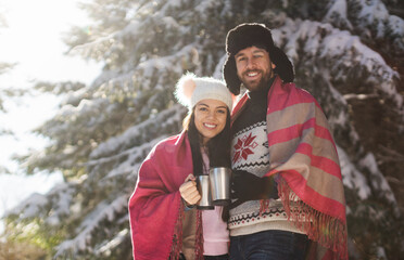 Front view of happy couple looking at camera holding coffee cup
