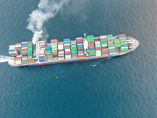 Aerial view of a large, loaded container cargo ship traveling over open ocea