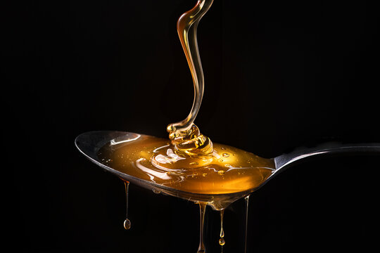 Honey pouring into a spoon
