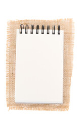 Notepad on jute, burlap. Notepad on white background - top view.  - 760066253