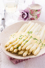 Traditional German white  asparagus with souce hollandaise served as close-up on a design plate