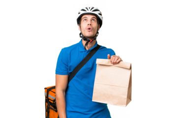 Young caucasian man taking a bag of takeaway food over isolated background looking up and with surprised expression