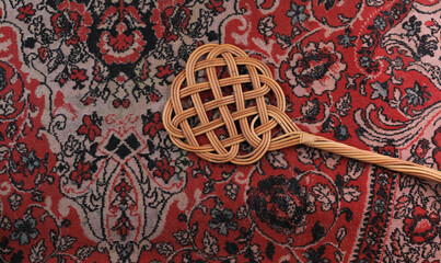 rattan beater on dirty carpet