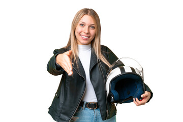 Young pretty blonde woman with a motorcycle helmet over isolated chroma key background shaking...