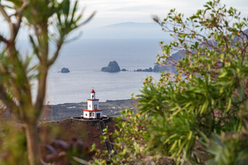 Campanario de Joapira church with green leaves in the foreground and La Palma in the background, La...