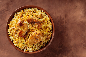 Chicken Biryani in Clay Bowl on Brown Background, Copy Space, Top View