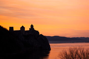 Sunset with a view of the mountains. The medieval castle is immersed in the orange setting sun....