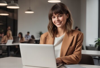 Young woman in beige jacket concentrating on laptop. Professional and dedicated business atmosphere. - obrazy, fototapety, plakaty