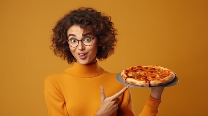 A young woman with curly glasses points at a pizza with a quirky expression, emphasizing fun and taste on an orange backdrop