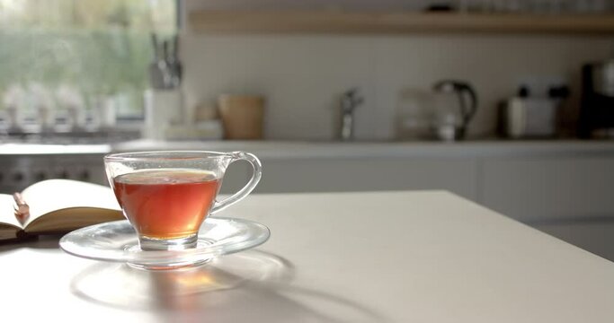 A cup of tea sits in focus on a table with copy space