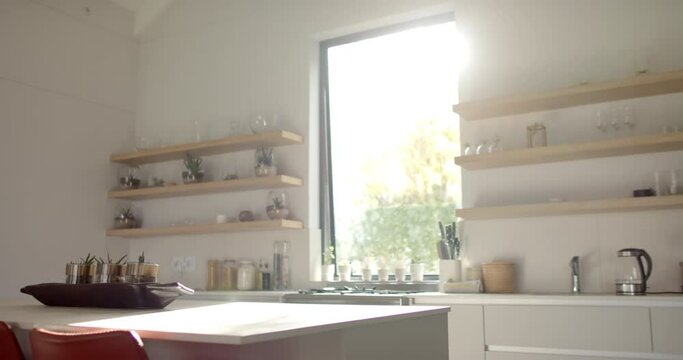 A modern kitchen basks in natural sunlight with copy space