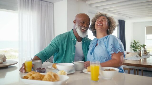 Mature couple on vacation or at home eating breakfast together - shot in slow motion