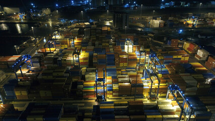 Industrial port at dawn. Aerial view of shipping container port terminal. Colourful pattern of containers in harbor.