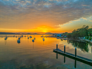Aerial sunrise over the water with boats and clouds