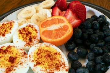 Close up of fresh and healthy breakfast: Hard boiled eggs with fruit and orange juice